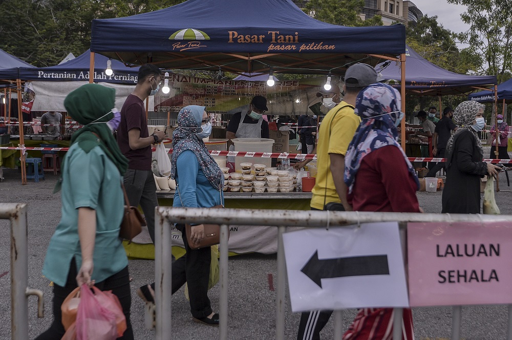 People are seen observing social distancing as the wait in line to enter the Putrajaya night market June 26, 2020. u00e2u20acu201d Picture by Shafwan Zaidon