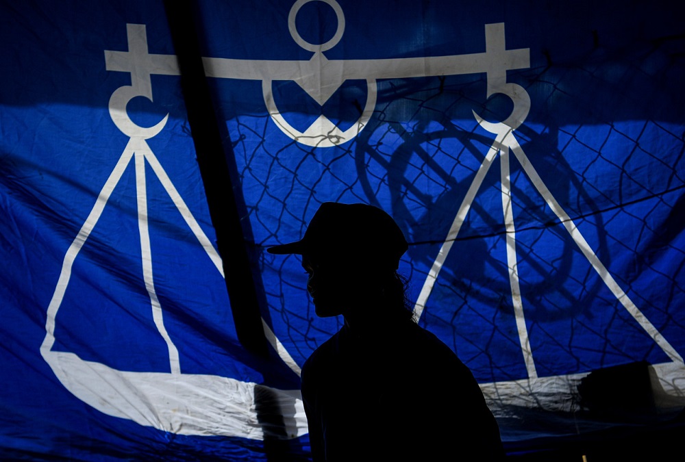 A man walks by a Barisan Nasional flag during the Chini by-election in Pekan June, 25, 2020. u00e2u20acu201d Bernama pic