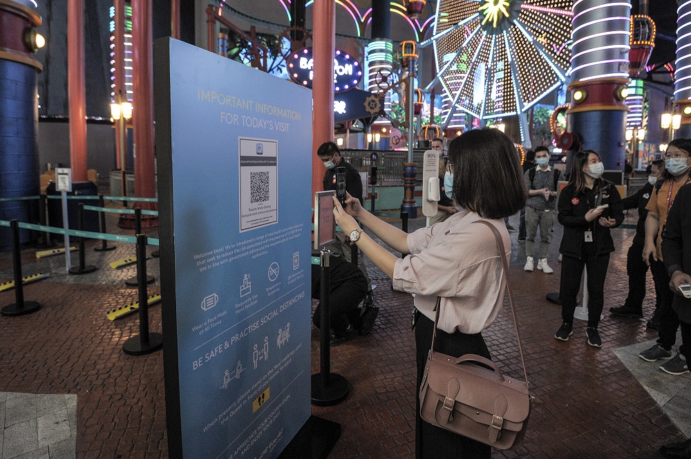 A visitor scans the mySejahtera QR code before entering the Genting Highlands theme park in Pahang June 19, 2020. u00e2u20acu2022 Picture by Shafwan Zaidon