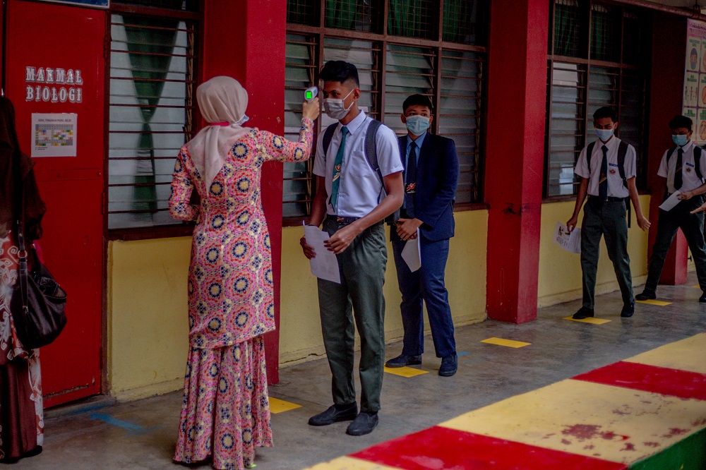 A student gets his temperature checked before entering the classroom at SMK Lembah Keramat Jaya in Kuala Lumpur June 24, 2020. u00e2u20acu2022 Picture by Firdaus Latif