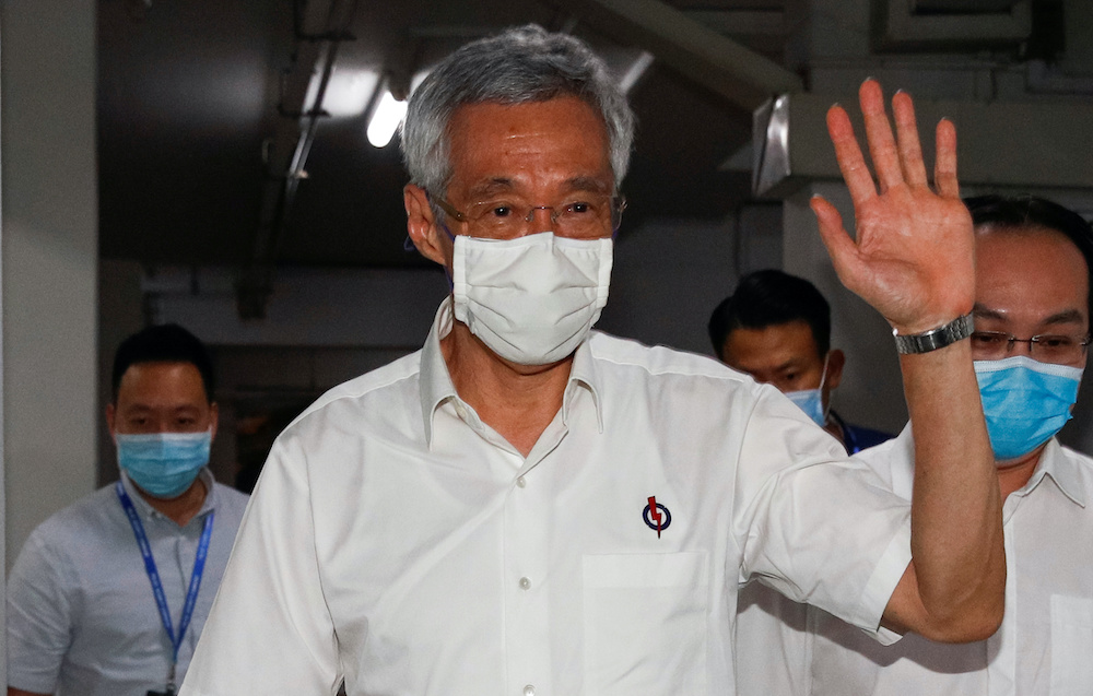Singapore's Prime Minister Lee Hsien Loong waves as he arrives at a People's Action Party branch office, as ballots are being counted during the general election, in Singapore July 11, 2020. u00e2u20acu201d Reuters pic