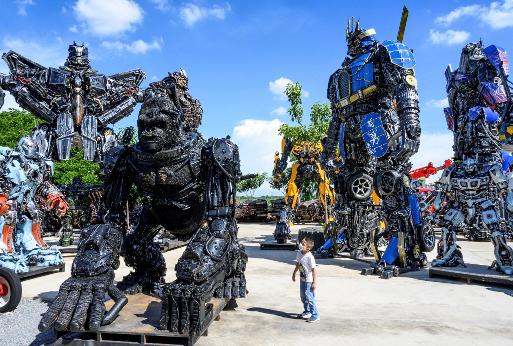 This photograph taken on July 18, 2020 shows a child looking at a figure of King Kong in front of life-sized sculptures of at the Ban Hun Lek museum in Ang Thong. u00e2u20acu201d AFP picn n