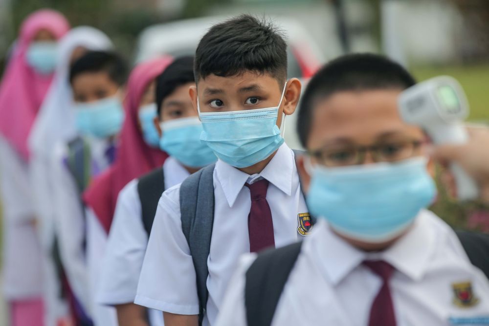 Sekolah Kebangsaan Jelapang students have their temperature checked on their first day back at school in Ipoh July 15, 2020. u00e2u20acu201d Picture by Farhan Najib
