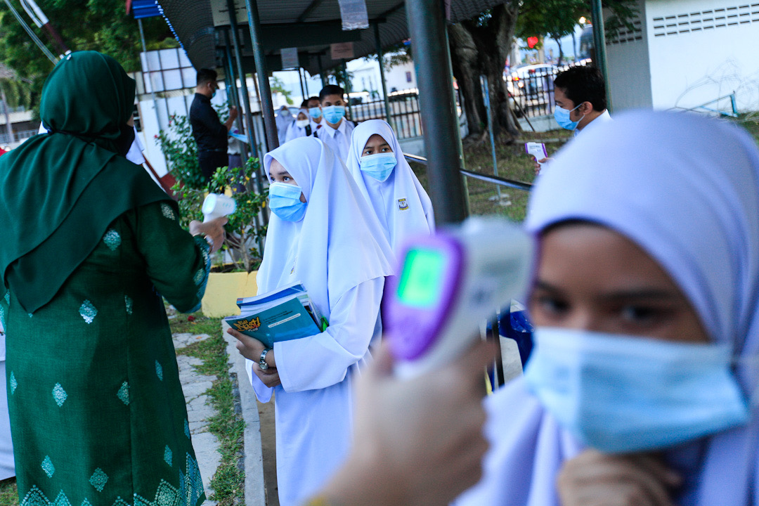 Sekolah Menengah Kebangsaan Raja Tun Uda students have their temperature checked on their first day back at school in Bayan Lepas July 15, 2020. u00e2u20acu201d Picture by Sayuti Zainudin