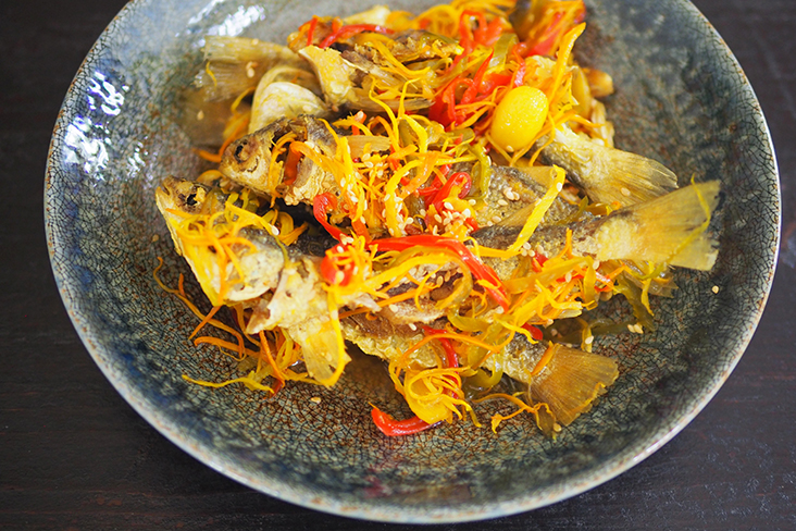 在一盘亚杂鱼中，共有七条被油煎至金黄色的小鱼，上面还撒满了红辣椒丝、黄姜和生姜。-Lee Khang Yi摄-