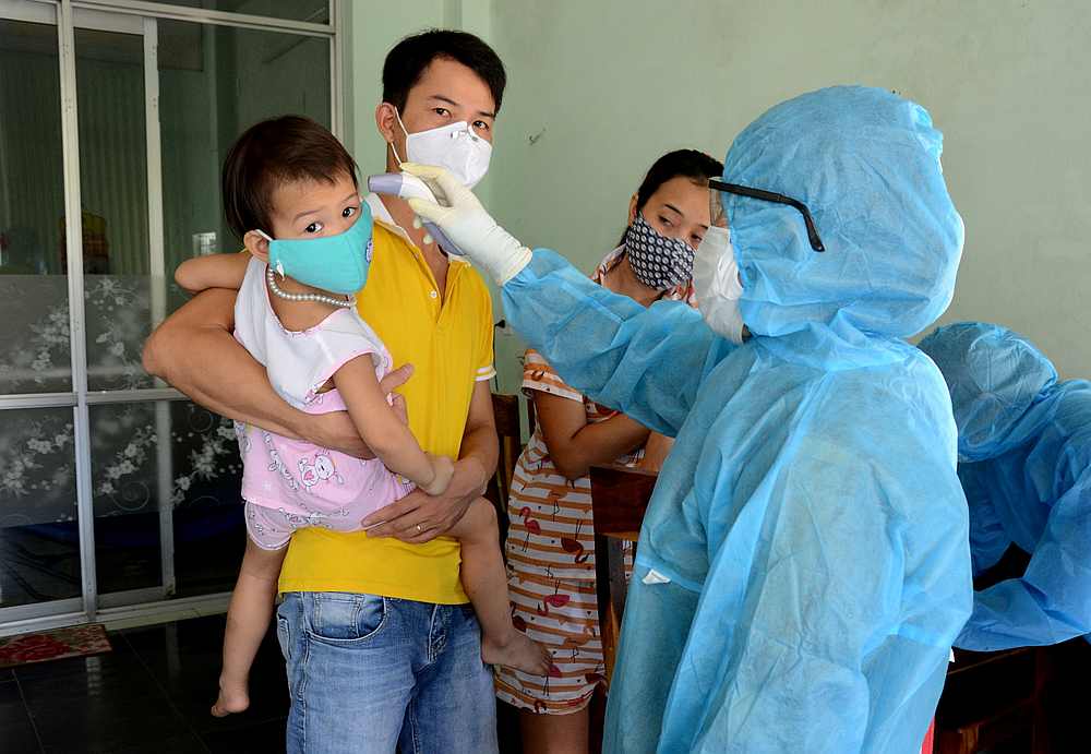 A health worker checks the temperature of residents at the area of a newly found coronavirus infected patient in Danang city, Vietnam July 26, 2020. u00e2u20acu201d VNA pic via Reuters