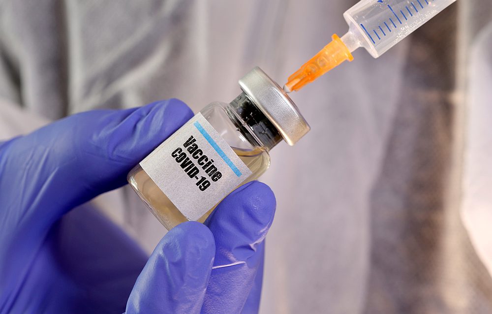A woman holds a small bottle labeled with a 'Vaccine Covid-19' sticker and a medical syringe in this illustration taken April 10, 2020. u00e2u20acu201d Reuters pic