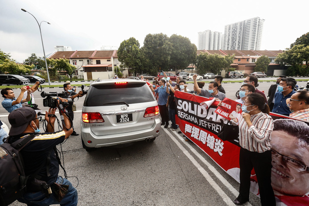 Supporters watch as a car transporting Penang Port Commission Chief Jeffrey Chew leaving the compound after his arrest by the MACC at Bayan Baru Police Station July 1, 2020. u00e2u20acu201d Picture by Sayuti Zainudin