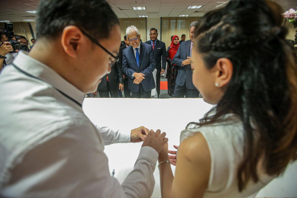 Home Minister Datuk Seri Hamzah Zainudin witnesses the wedding registration of Chinese couple Wong Wai Ying and Ng Mung Hong at the National Registration Department in Putrajaya July 20, 2020. u00e2u20acu201d Picture by Hari Anggara