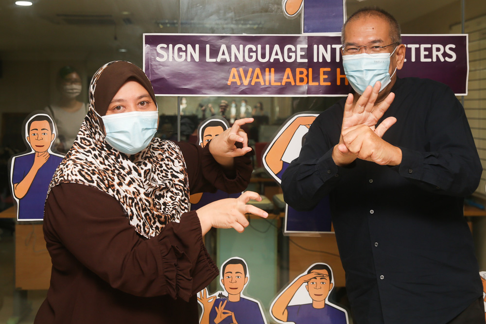 艾美诺（左）和萨扎利向记者演示“病毒”和“Covid-19”的手语。-Choo Choy May摄-