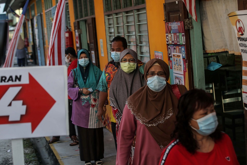 People are seen practising social distancing while waiting in line to cast their ballots at the Sekolah Kebangsaan Aminnudin Baki polling station in Slim River August 29, 2020. u00e2u20acu201d Picture by Farhan Najib