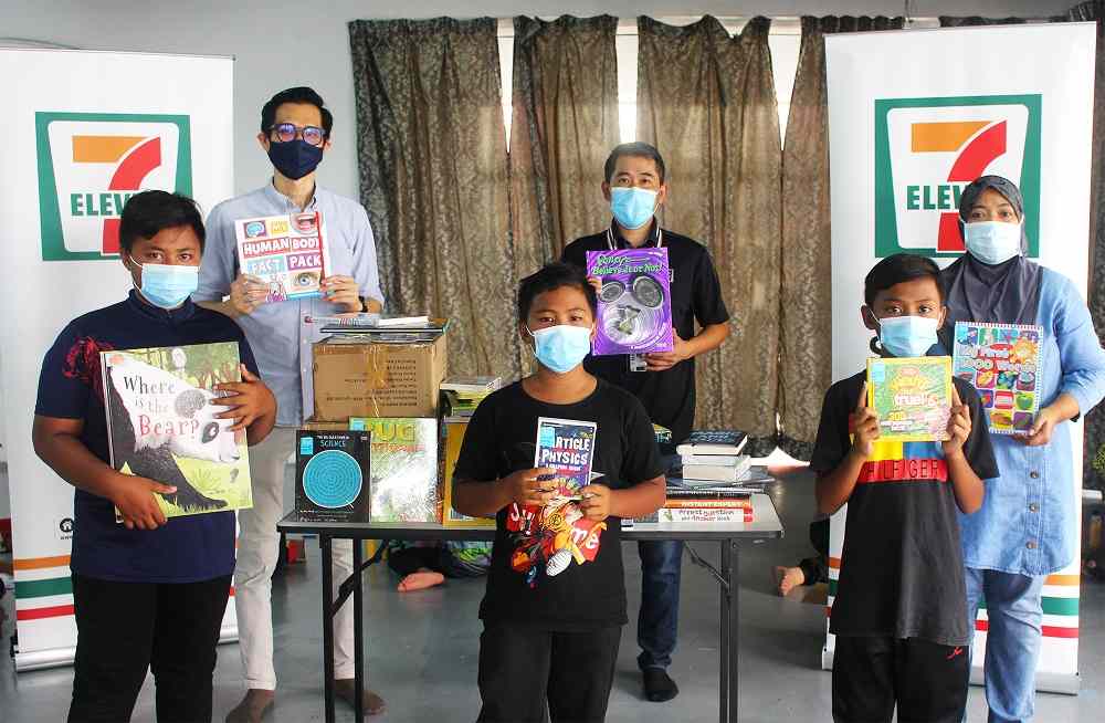 (From left) NGOhub managing director Chun Wah Hoo, 7-Eleven Malaysia marketing general manager Ronan Lee and Raudhatul Nurr Jannah caretaker Zurina Zainudin with some of the children and books received. u00e2u20acu201d Picture courtesy of 7-Eleven Malaysia