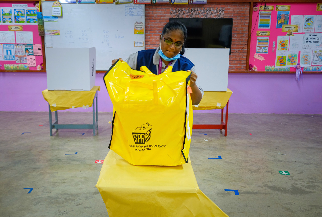 An Election Commission officer carries a ballot box to one of the voting booths at the Sekolah Jenis Kebangsaan Tamil Trolak in Tanjung Malim August 29, 2020. u00e2u20acu201d Bernama pic