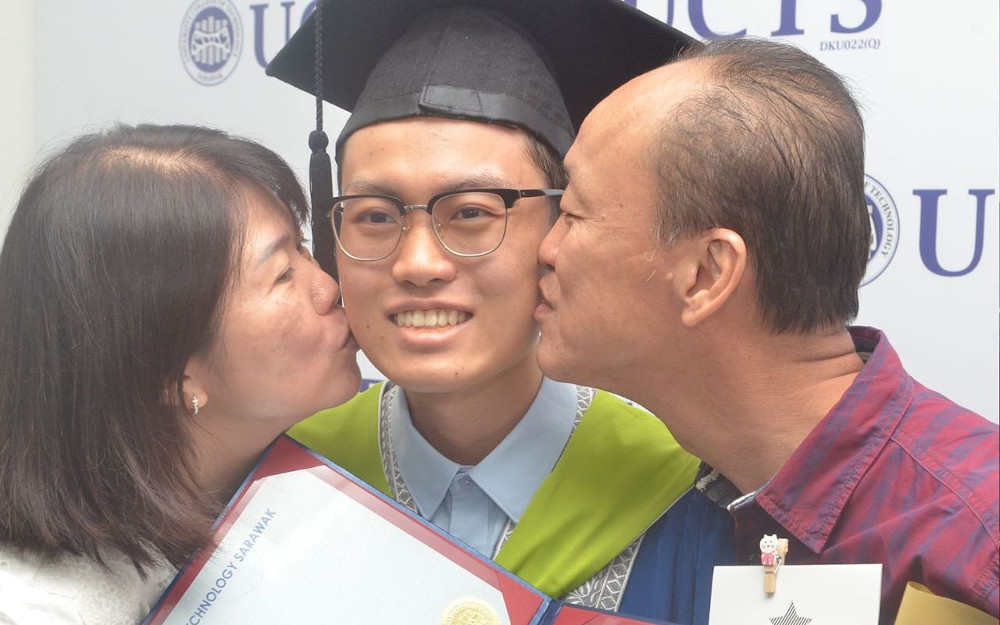 Phu Joon Meng was all smiles with his parents at the special ceremony August 18, 2020. u00e2u20acu201d Picture from Facebook/uctsofficialn