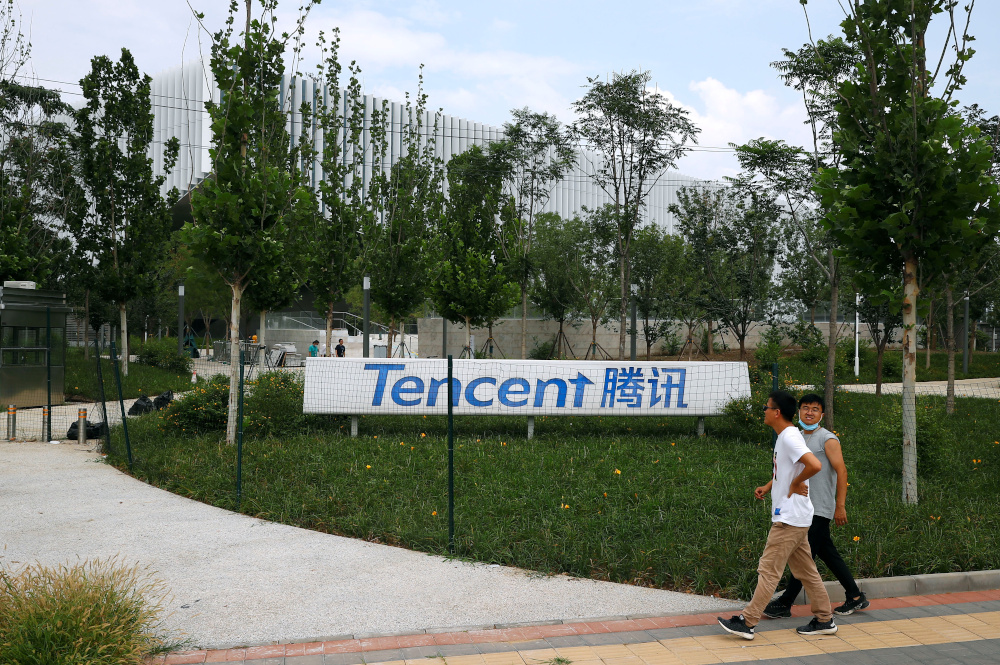 People walk past an office building of Chinese tech firm Tencent, owner of messaging app WeChat, in Beijing, China August 7, 2020. u00e2u20acu201d Reuters picn
