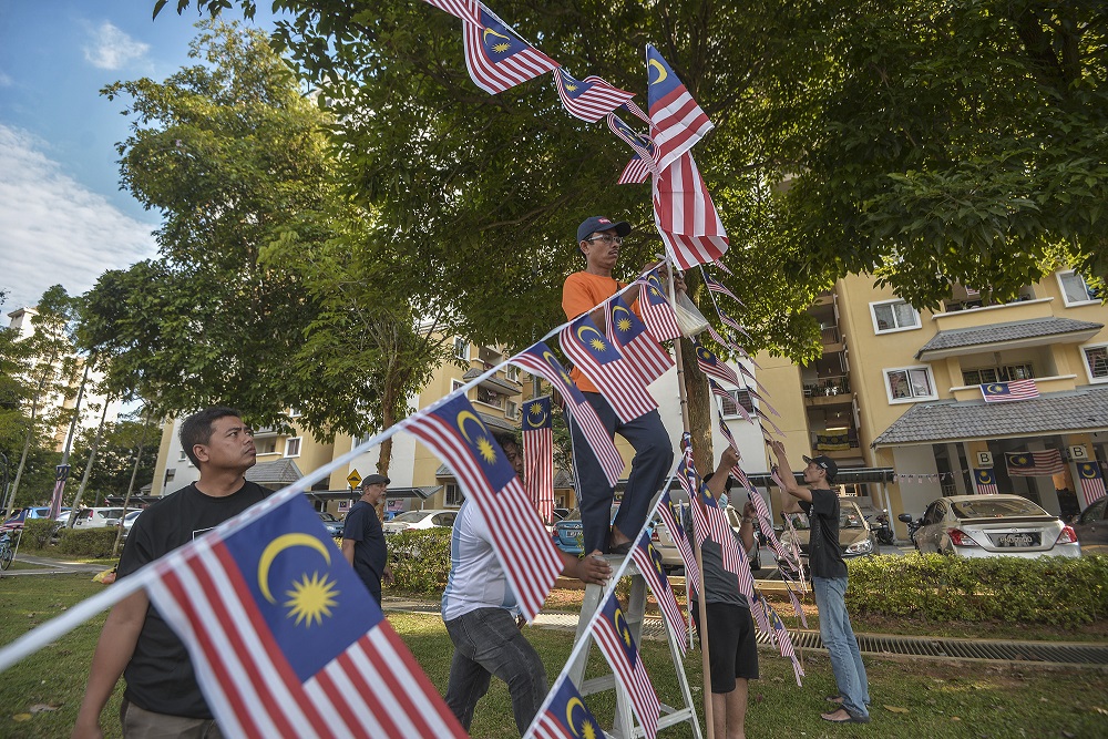 Residents are seen putting up the Jalur Gemilang in front of their houses in Precinct 8 Putrajaya August 20, 2020. u00e2u20acu2022 Picture by Shafwan Zaidon