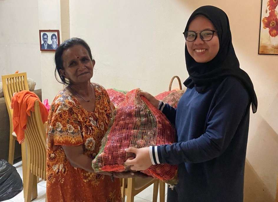 Roob Ganesan's friend, Adibah Atiqah, giving Mahamachumy a sack of onions to be peeled August 4, 2020. u00e2u20acu201d Picture courtesy of Roob Ganesan