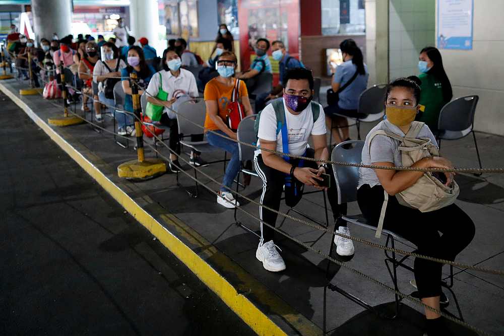 Passengers wearing masks for protection against Covid-19 maintain social distancing while queueing to ride a bus in Manila, Philippines July 14, 2020. u00e2u20acu201d  Reuters pic