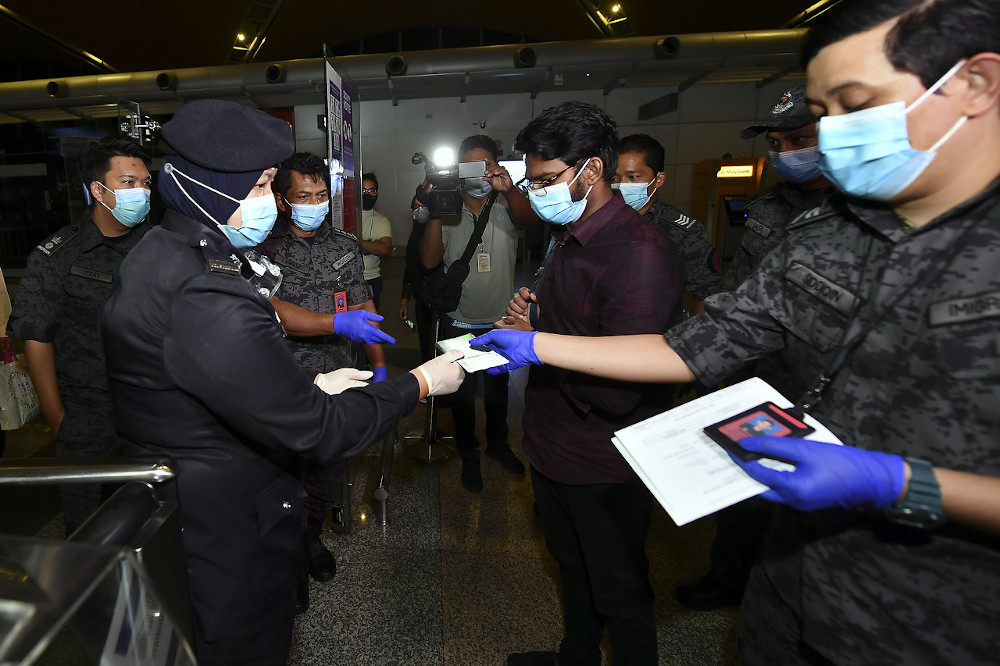 Md Rayhan Kabir getting his travel documents checked by airport security at the Kuala Lumpur International Airport, August 21, 2020. u00e2u20acu201d Bernama pic 