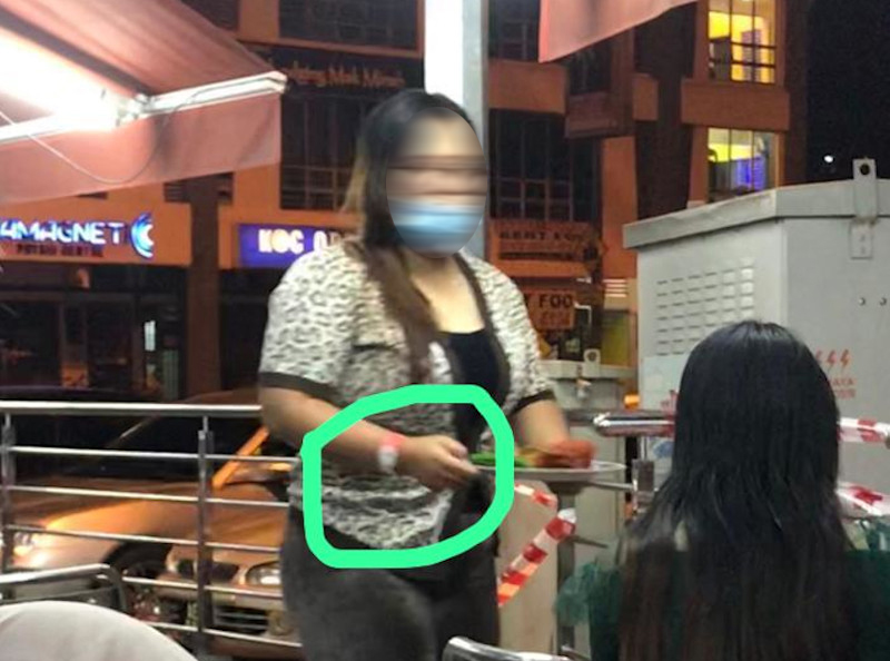 Picture of a woman sporting the pink Person Under Surveillance for Covid-19 wristband and dining out at a restaurant said to be in Ipoh, Perak were shared online today. u00e2u20acu201d Picture from social media