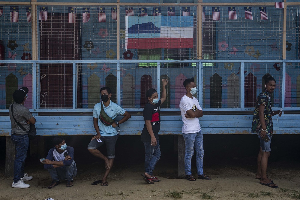 Voters wearing protective masks queue up to cast their votes during the Sabah state election in SK Pulau Gaya September 26, 2020. u00e2u20acu201d Picture by Firdaus Latif