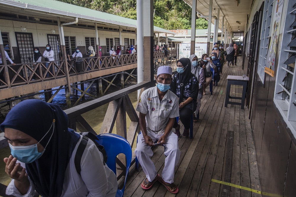 Voters wearing protective masks queue up to cast their votes during the Sabah state election in SK Pulau Gaya September 26, 2020. u00e2u20acu201d Picture by Firdaus Latif