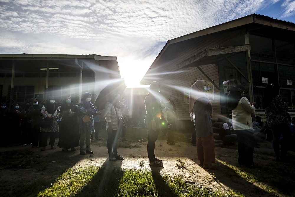 Voters wearing protective masks queue up to cast their votes during the Sabah state election in SK Pulau Gaya September 26, 2020. u00e2u20acu201d Picture by Firdaus Latif