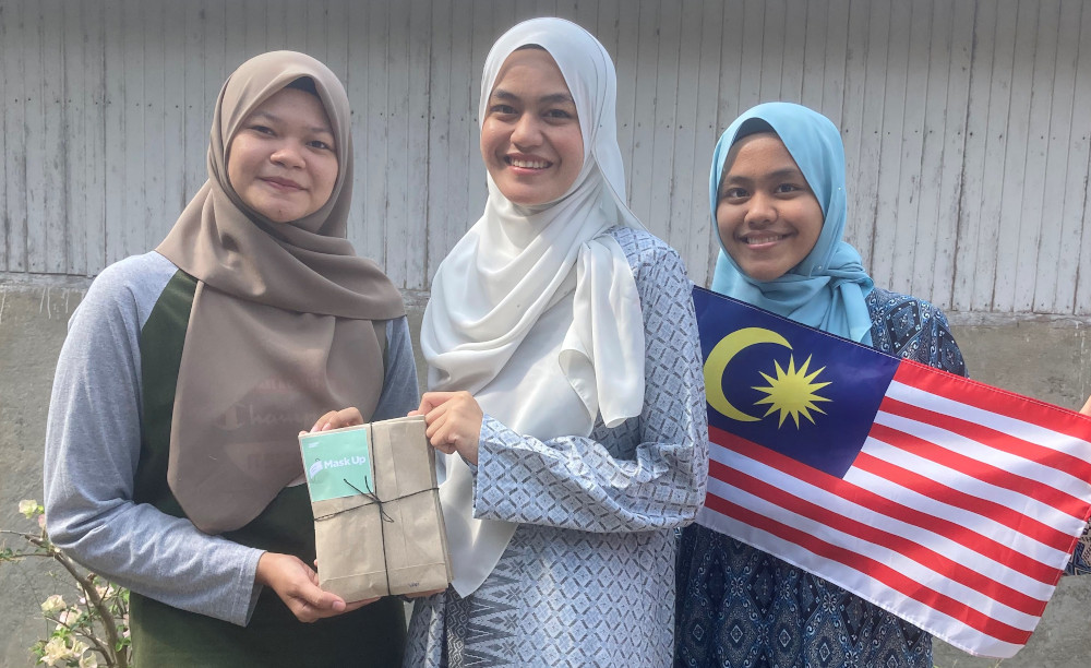 Absarina Zakaria (centre) and Raudhah Zakaria (right) distributing face masks to communities in Hulu Terengganu yesterday. u00e2u20acu201d Picture by Absarina Zakaria