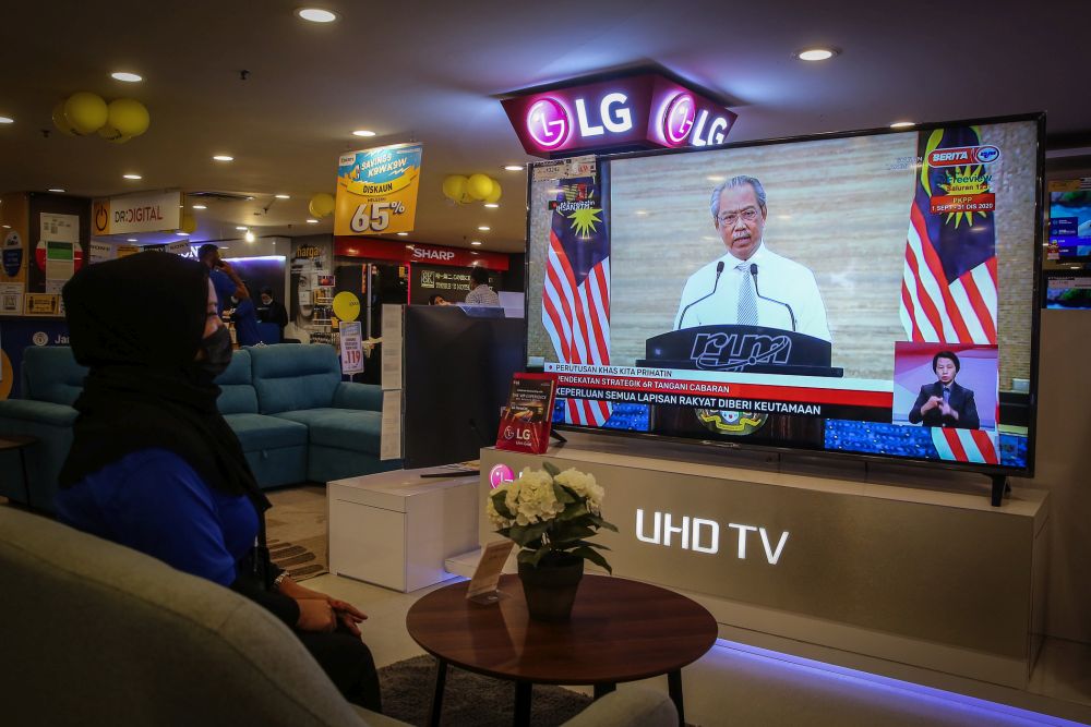 A woman watches a live telecast of Prime Minister Tan Sri Muhyiddin Yassinu00e2u20acu2122s speech in Kuala Lumpur September 23, 2020. u00e2u20acu2022 Picture by Yusof Mat Isa 