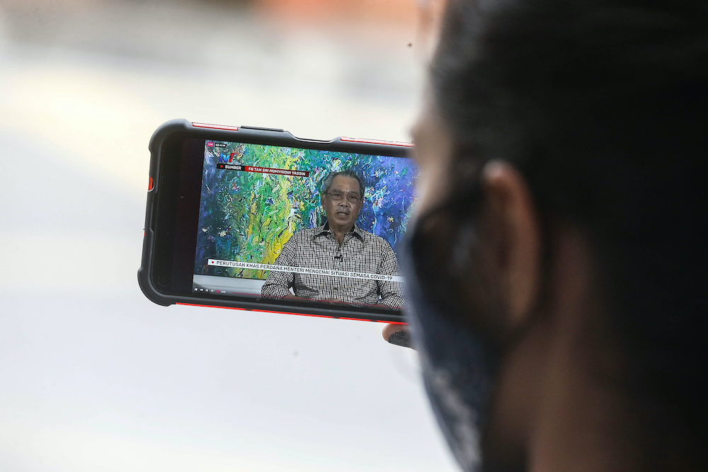 A woman watches the special announcement by Prime Minister Tan Sri Muhyiddin Yassin on her smartphone, October 6, 2020. u00e2u20acu201d Picture by Sayuti Zainudin