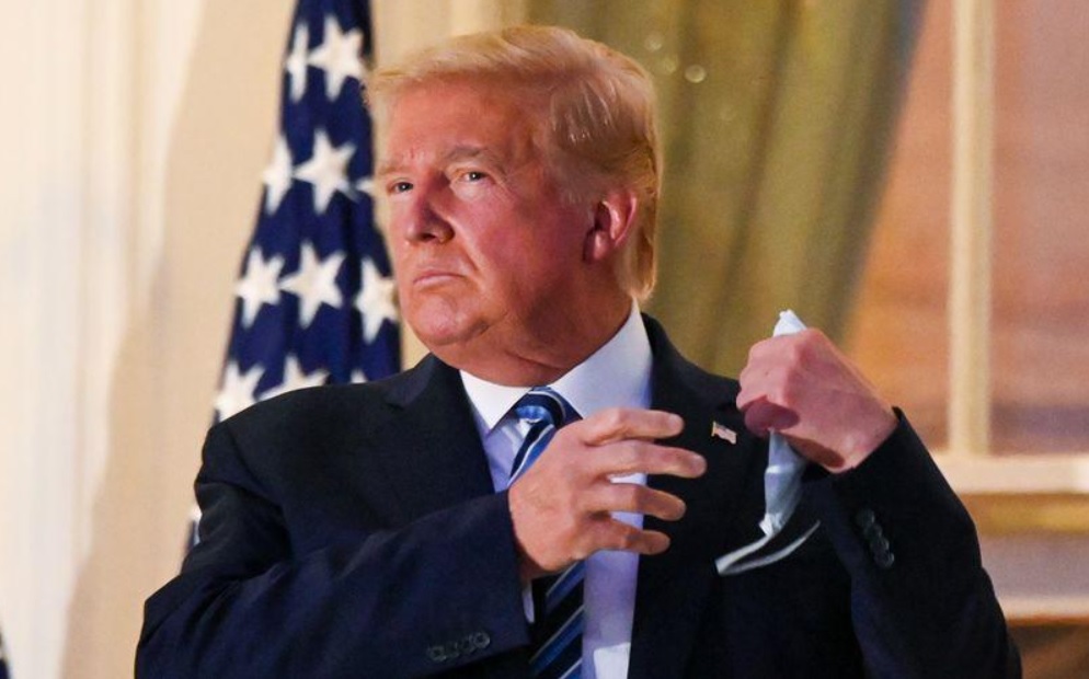 US President Donald Trump pulls off his protective face mask as he poses atop the Truman Balcony of the White House in Washington October 5, 2020. u00e2u20acu2022 Reuters pic