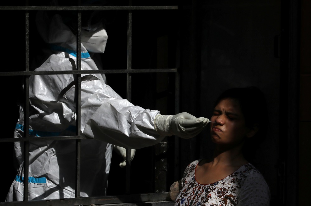 A healthcare worker wearing personal protective equipment collects a swab sample from a woman, amid the spread of the coronavirus disease in New Delhi September 29, 2020. u00e2u20acu201d Reuters pic