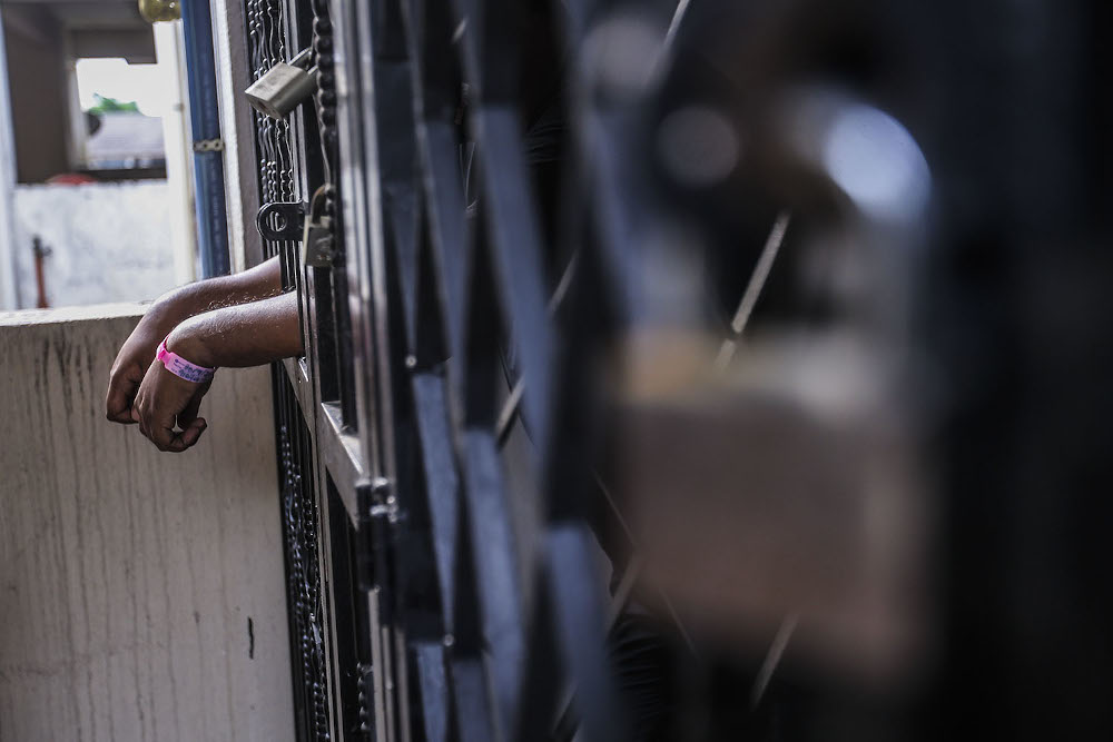 A man is seen standing at his house gate after being ordered to undergo home quarantine in Kuala Lumpur October 4, 2020. u00e2u20acu201d Picture by Hari Anggara.