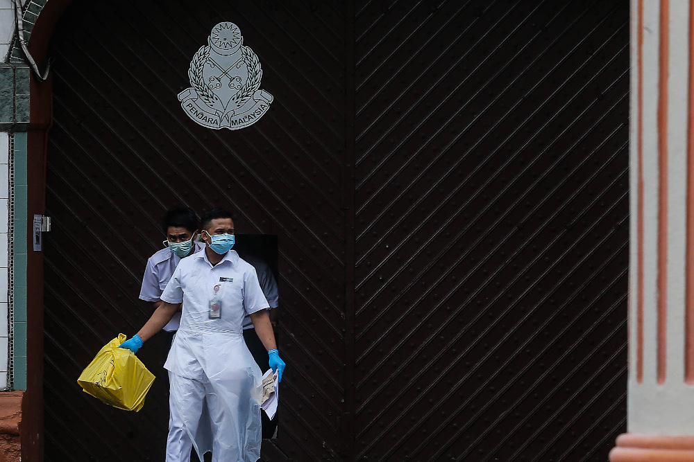 Penang Health Dept personnel are seen holding bags believed to be Covid-19 swab specimens after six inmates tested positive for Covid-19 at the Penang Prison, October 8, 2020. u00e2u20acu201d Picture by Sayuti Zainudin