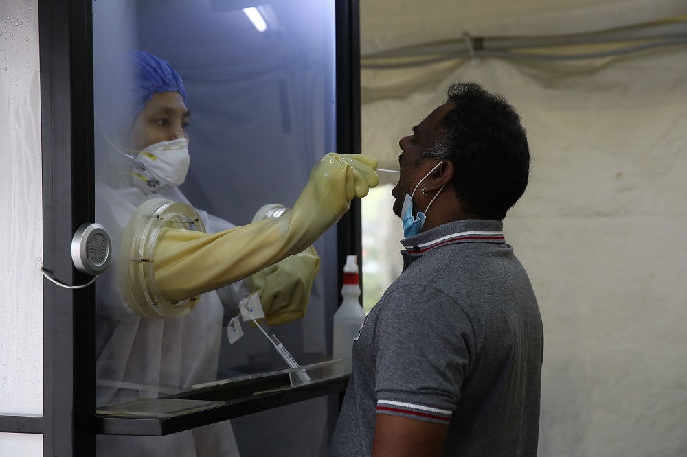 A health worker inside a protective chamber collects swab samples to test for Covid-19 at the Sunway Medical Centre in Subang Jaya October 15, 2020. u00e2u20acu201d Picture by Yusof Mat Isa