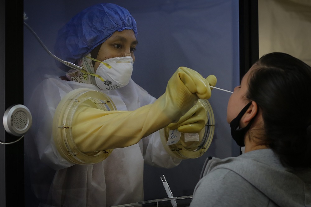 A health worker inside a protective chamber collects swab samples to test for Covid-19 at the Sunway Medical Centre in Subang Jaya October 15, 2020. u00e2u20acu201d Picture by Yusof Mat Isa