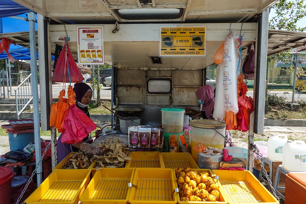 A petty trader sells fried snacks at her stall in Petaling Jaya October 27, 2020. u00e2u20acu201d Picture by Miera Zulyana
