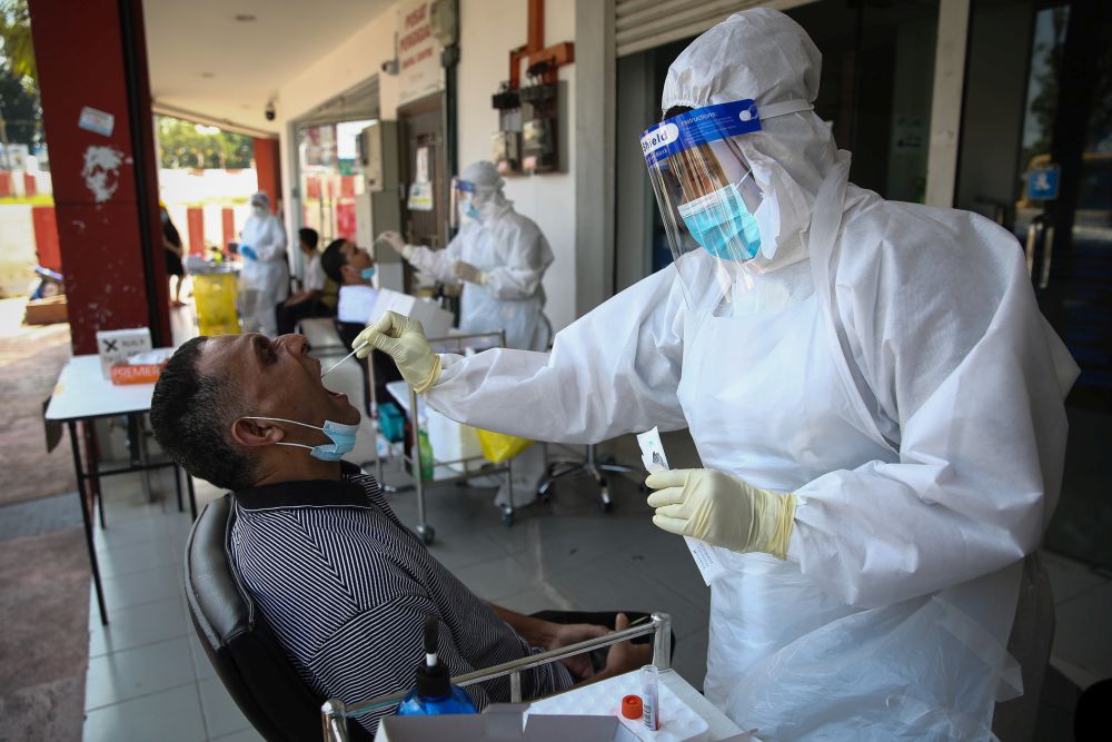 A healthcare worker collects swab samples to test for Covid-19 at BP Healthcare in Klang October 27, 2020. u00e2u20acu201d Picture by Yusof Mat Isa