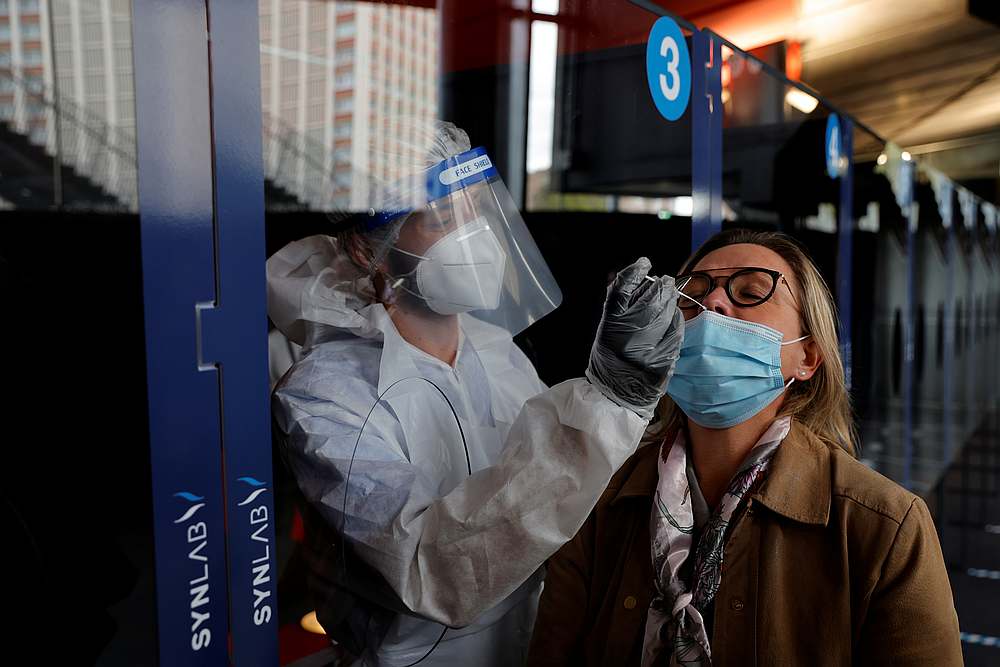 A health worker, wearing a protective suit and a face mask, administers a nasal swab to a patient in a temporary testing site for Covid-19 at the Zenith Arena in Lille, France, October 15, 2020.nu00e2u20acu201d Reuters pic