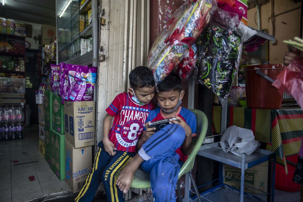 Children play with a mobile phone during the conditional movement control order in Kampung Baru, Kuala Lumpur October 27, 2020. u00e2u20acu201d Picture by Firdaus Latif