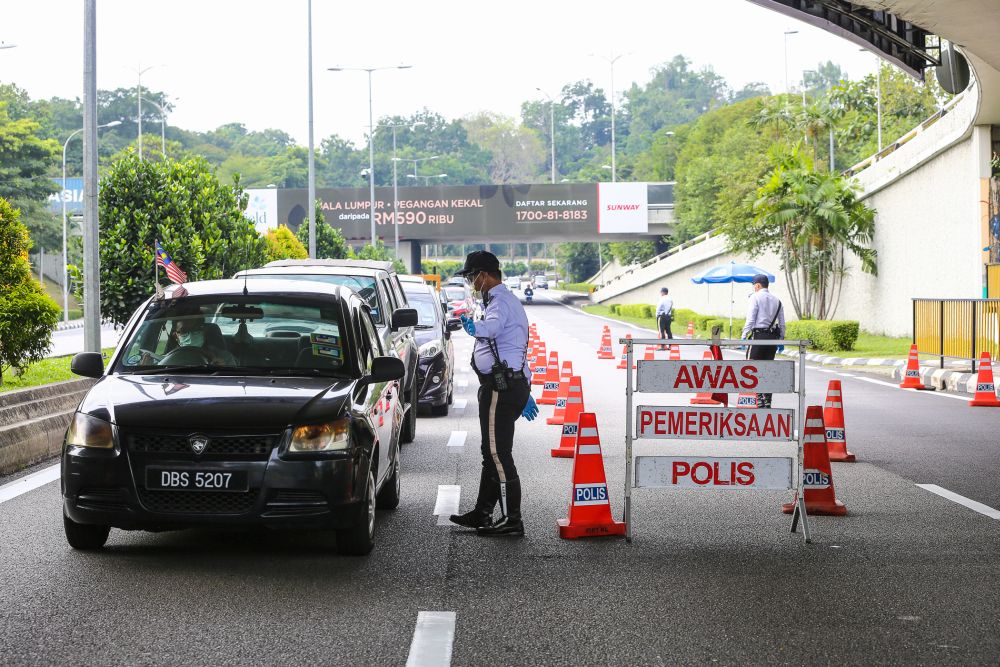 A traffic policeman conducts checks on vehicles during a roadblock on Jalan Sultan Ismail in Kuala Lumpur October 14, 2020. u00e2u20acu201d Picture by Yusof Mat Isann