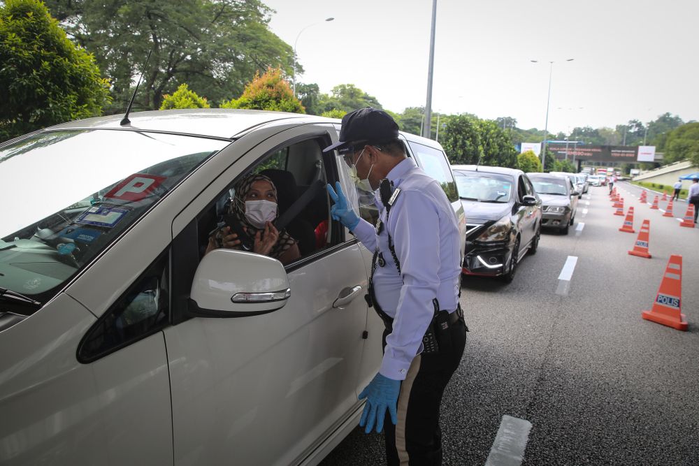 A traffic policeman conducts checks on vehicles during a roadblock on Jalan Sultan Ismail in Kuala Lumpur October 14, 2020. u00e2u20acu201d Picture by Yusof Mat Isann