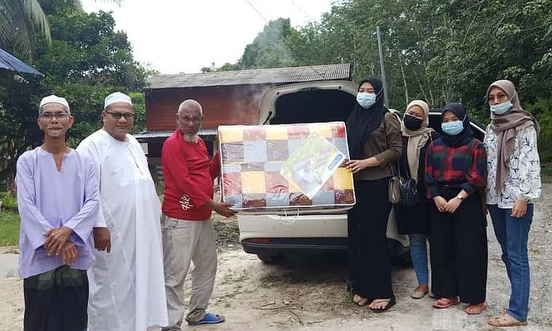 Villagers helping Aid (in red) carry the items from Nafeesya's car to Aid's house. u00e2u20acu201d Picture via Twitter/Nafeesya