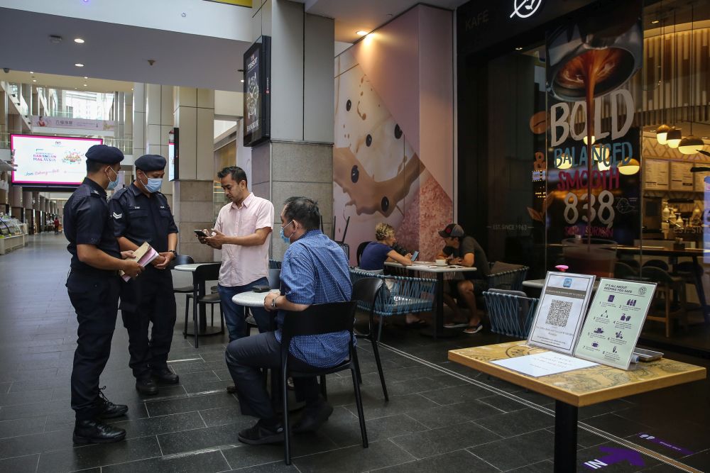警察在Pavillion购物中心检查顾客的行踪记录。-Yusof Mat Isa摄-