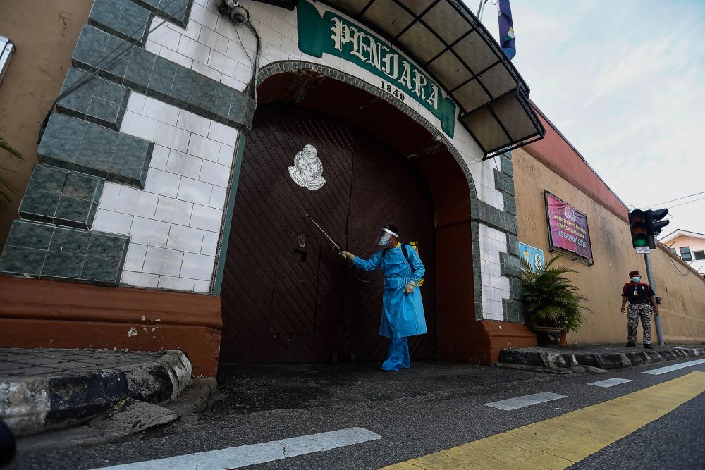 A Penang Remand Prison staff is seen disinfecting the main entrance October 14, 2020. u00e2u20acu201d Picture by Sayuti Zainudin