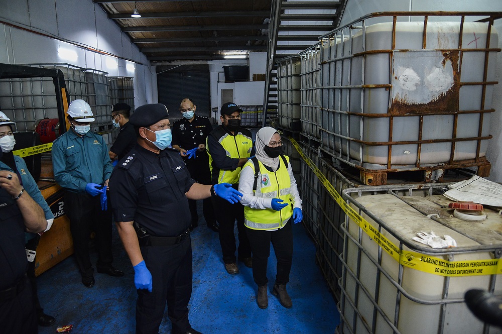 Gombak police chief Arifai Tarawei (centre) inspects the barrels containing chemicals at Taman Velox in Rawang November 11,2020. u00e2u20acu201d Picture by Miera Zulyana