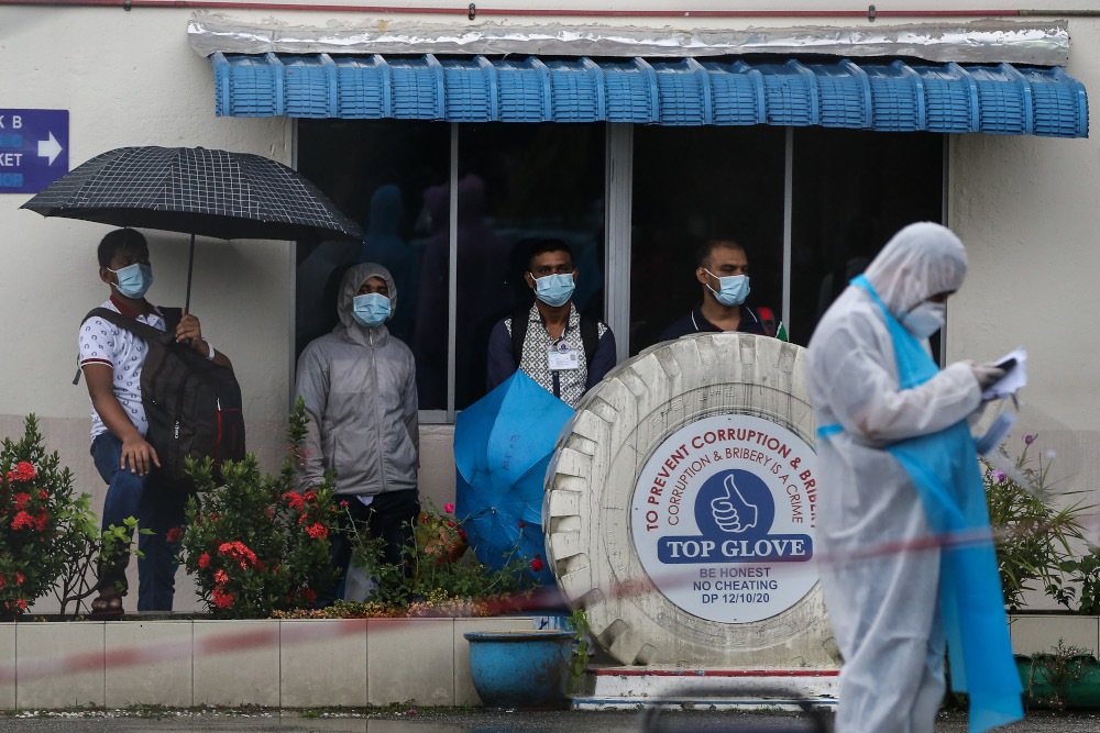 Top Glove workers wait in line outside the staff dormitories in Klang before being transported to the Sungai Buloh and Kuala Lumpur General Hospital November 24, 2020. u00e2u20acu201d Picture by Yusof Mat Isa