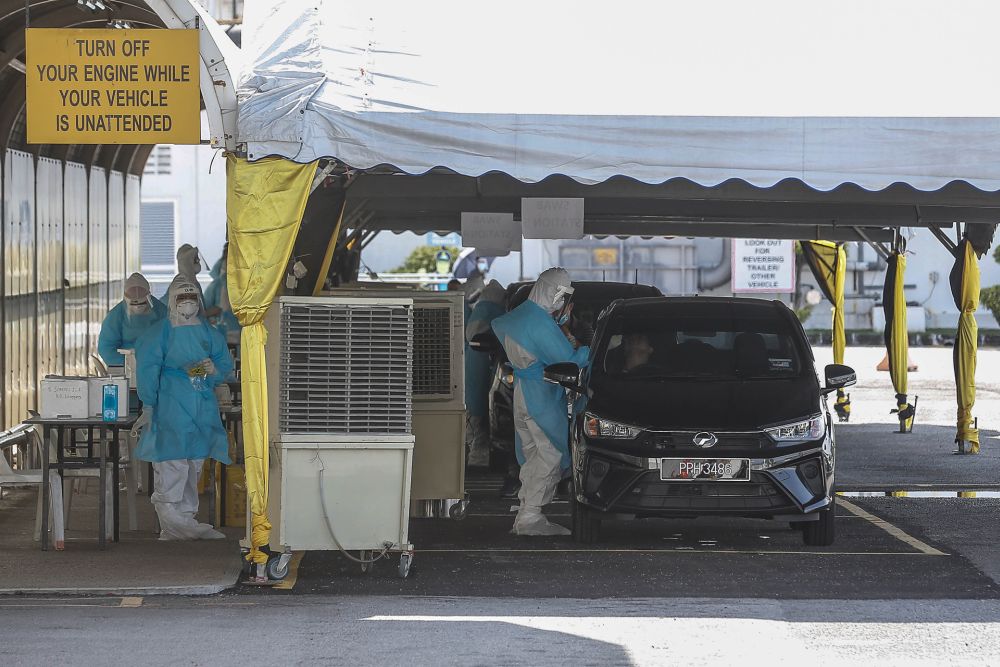 Health workers collect swabs at a Covid-19 drive-through testing site at a factory in the Bayan Lepas Industrial Zone  November 12, 2020. u00e2u20acu201d Picture by Sayuti Zainudin