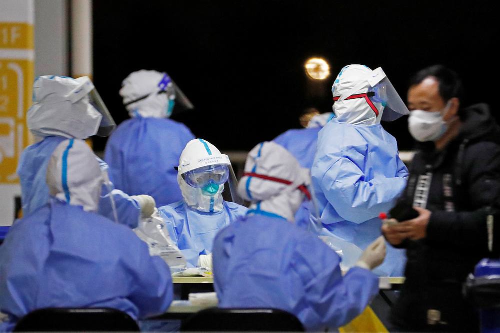 Workers in protective suits seen at a makeshift nucleic acid testing site inside a parking lot of Shanghai Pudong International Airport, after new Covid-19 cases in Shanghai, China November 22, 2020. u00e2u20acu201du00e2u20acu201d cnsphoto via Reuters