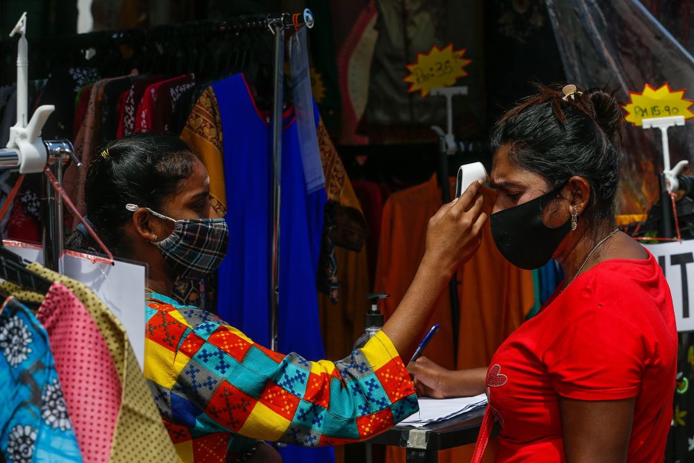 A shopper has her temperature taken at a clothing store in Little India, George Town ahead of Deepavali celebrations November 13, 2020. u00e2u20acu201d Picture by Sayuti Zainudin